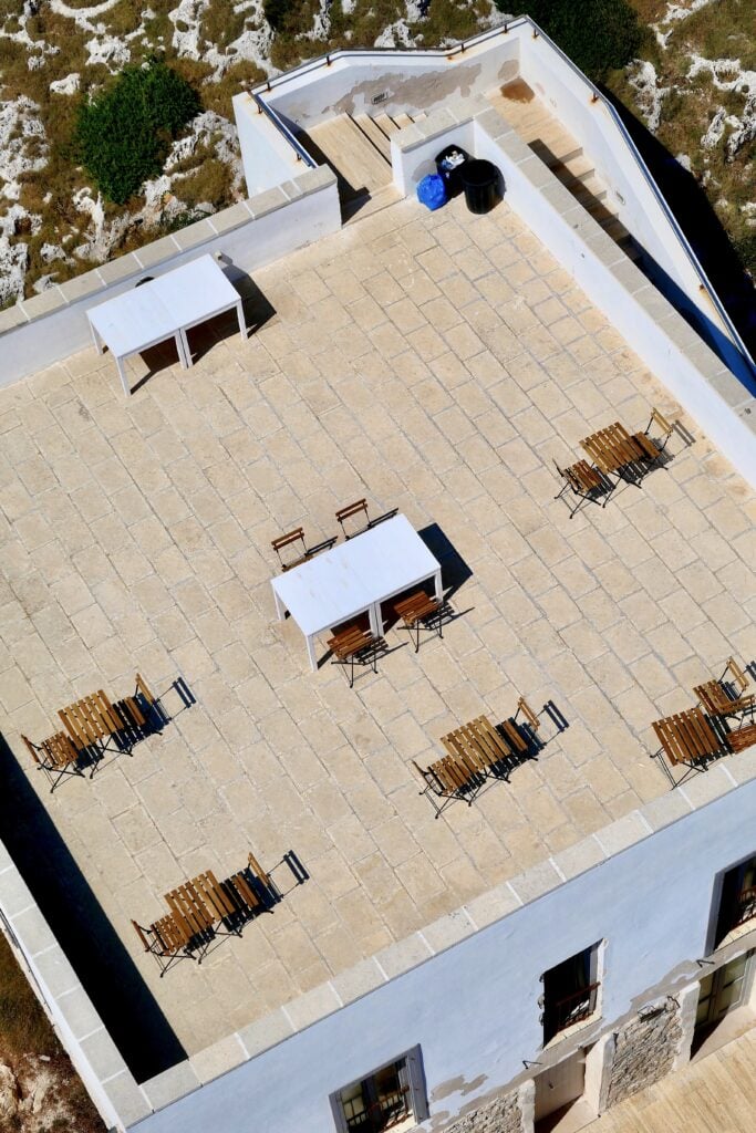 A vertical high angle shot of a cafe on a rooftop of a light blue building