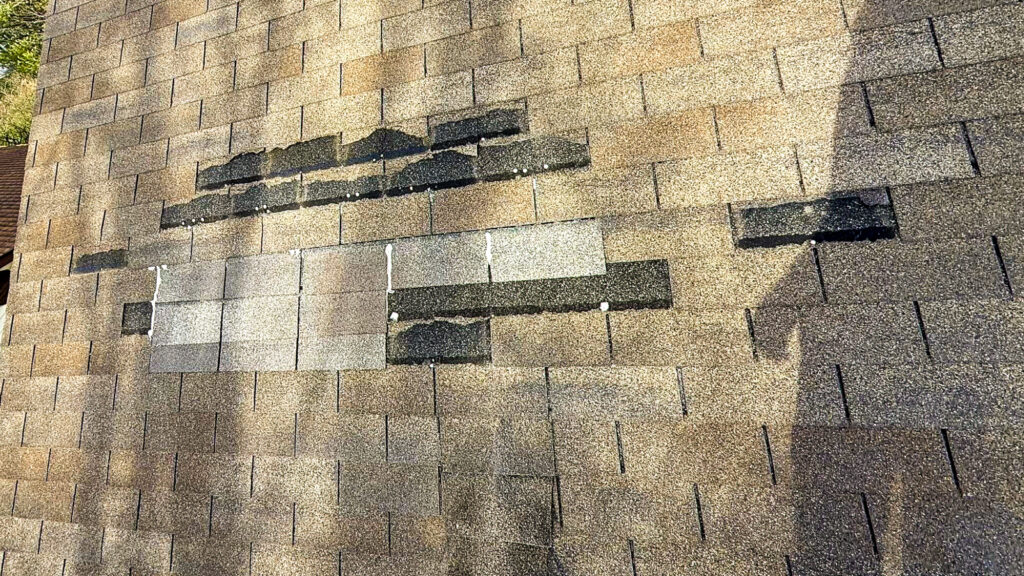 Roof leaks during heavy rain causing visible water damage on residential roof in storm conditions