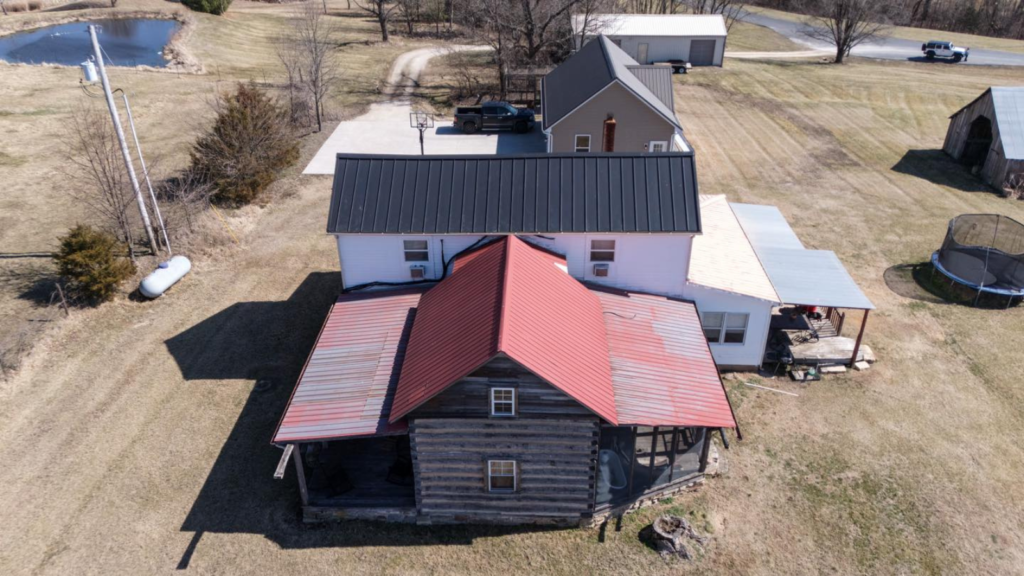 Storm damage roofing Washington MO showing homeowner inspecting roof after hail and wind storm with visible shingle damage and debris