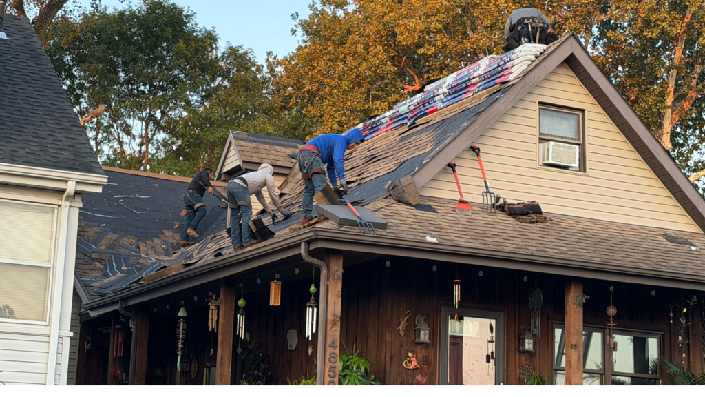 professional roof tear-off crew removing old shingles down to the deck